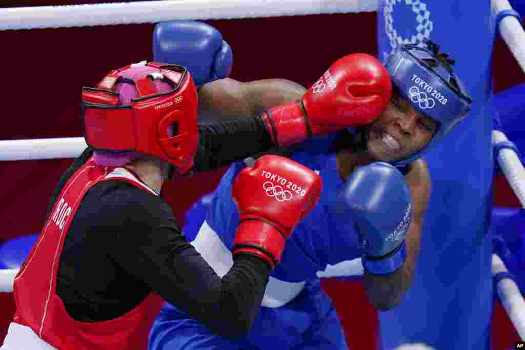 Zenfira Magomedalieva, of the Russian Olympic Committee, left, exchanges punches with Mozambique's Rady Adosinda Gramans during their women's middleweight 75-kg boxing match at the 2020 Summer Olympics, Saturday, July 31, 2021, in Tokyo, Japan. (AP Photo/Frank Franklin II)