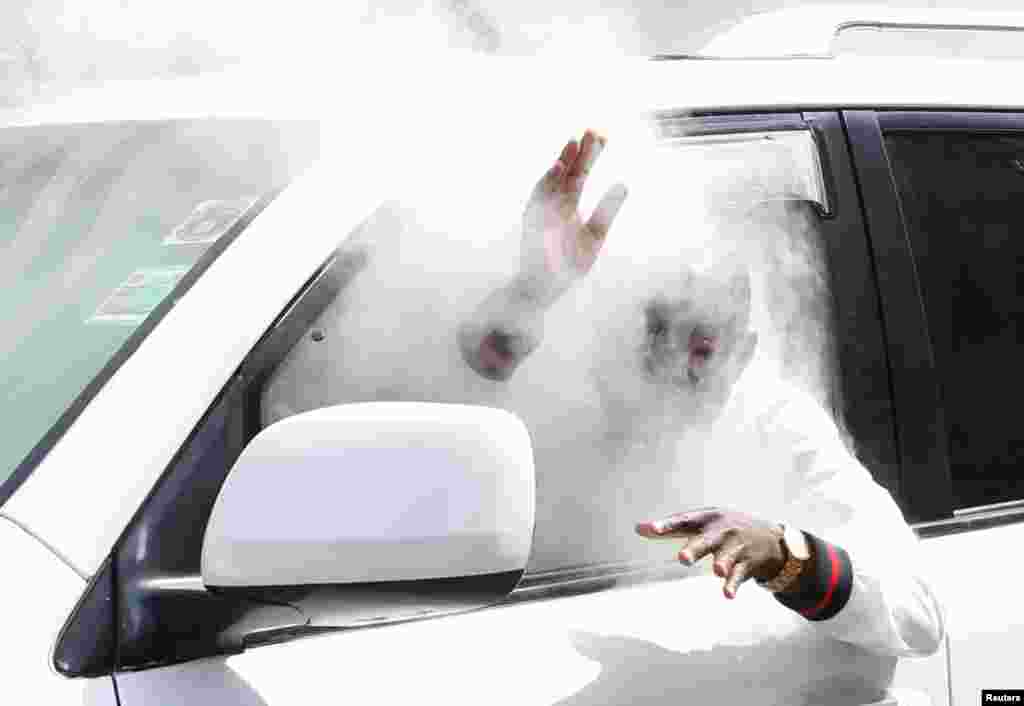 An opposition politician of the National Super Alliance (NASA) coalition, reacts after a gas canister fired by policemen hits his car during a protest along a street in Nairobi, Kenya.