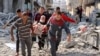 Wasu Falasdinawa dauke da wani tsohon mutun a kan kujera bayan tankokin Isra’ila sun kutsa da kai hari a Jabalia arewacin Gaza - Nuwamba 10, 2024.