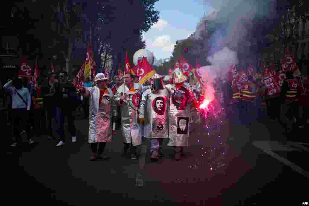 French metalworkers demonstrate as they march with flares, banners and flags in the streets of Paris.