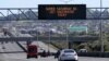 FILE - A sign on an Auckland motorway urges people to get vaccinated at a COVID-19 vaccination clinic during a single-day vaccination drive, in Auckland, New Zealand, Oct. 16, 2021. 
