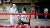 China -- A medical worker in protective suit conducts nucleic acid testings for residents at a residential compound in Wuhan, the Chinese city hit hardest by the coronavirus disease (COVID-19) outbreak, Hubei province, China May 15, 2020.