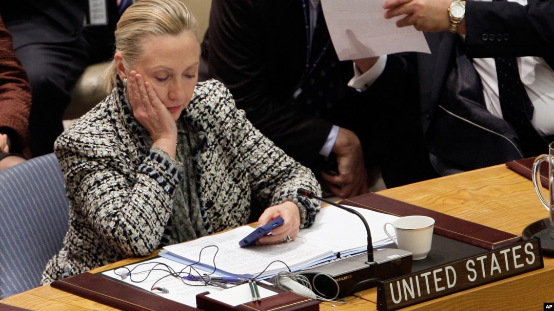 FILE - Then U.S. secretary of state Hillary Clinton checks her mobile phone after delivering an address to the Security Council at United Nations headquarters in New York, March 12, 2012.