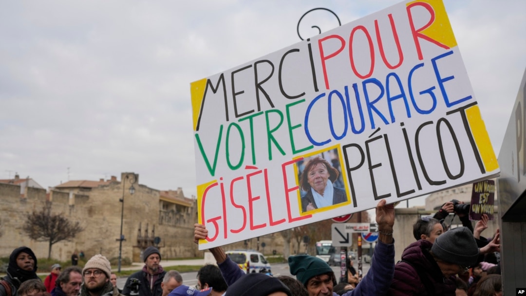A man holds a placard reading 'Thank you for your courage Gisele Pelicot' outside the Avignon courthouse, southern France, Dec. 19, 2024. 