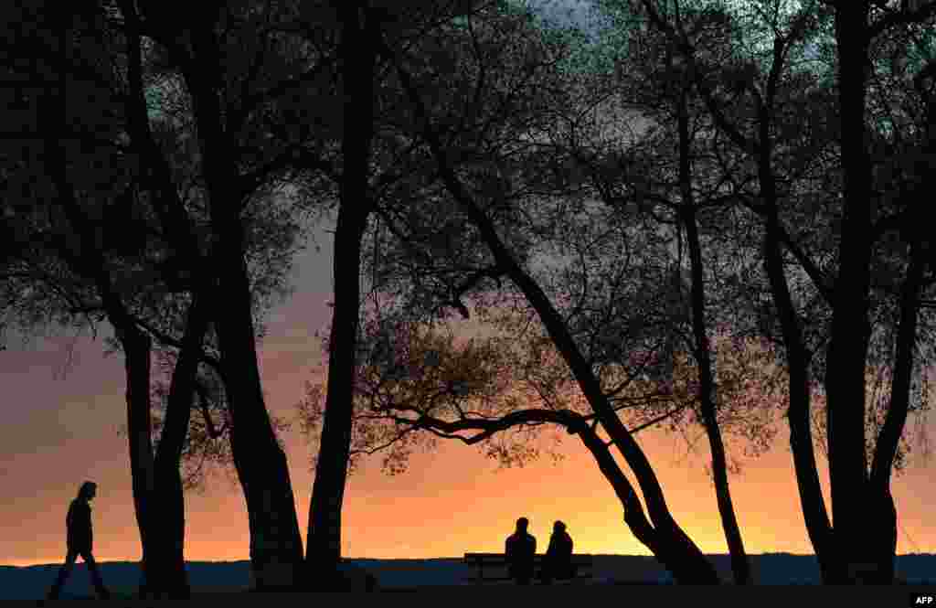 A man walks along the lake Amer (Amersee) at sunset in the small Bavarian village of Herrsching, southern Germany, Nov. 1, 2017.