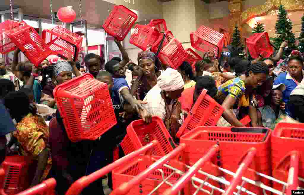 People reached out to pick baskets at a newly commissioned Shoprite store at Novare Gateway mall Abuja, Nigeria.
