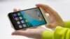 FILE - A woman shows the new LG's G5 smartphone during the LG unpacked 2016 event on the eve of this week’s Mobile World Congress wireless show, in Barcelona, Spain, Feb. 21. 2016. 