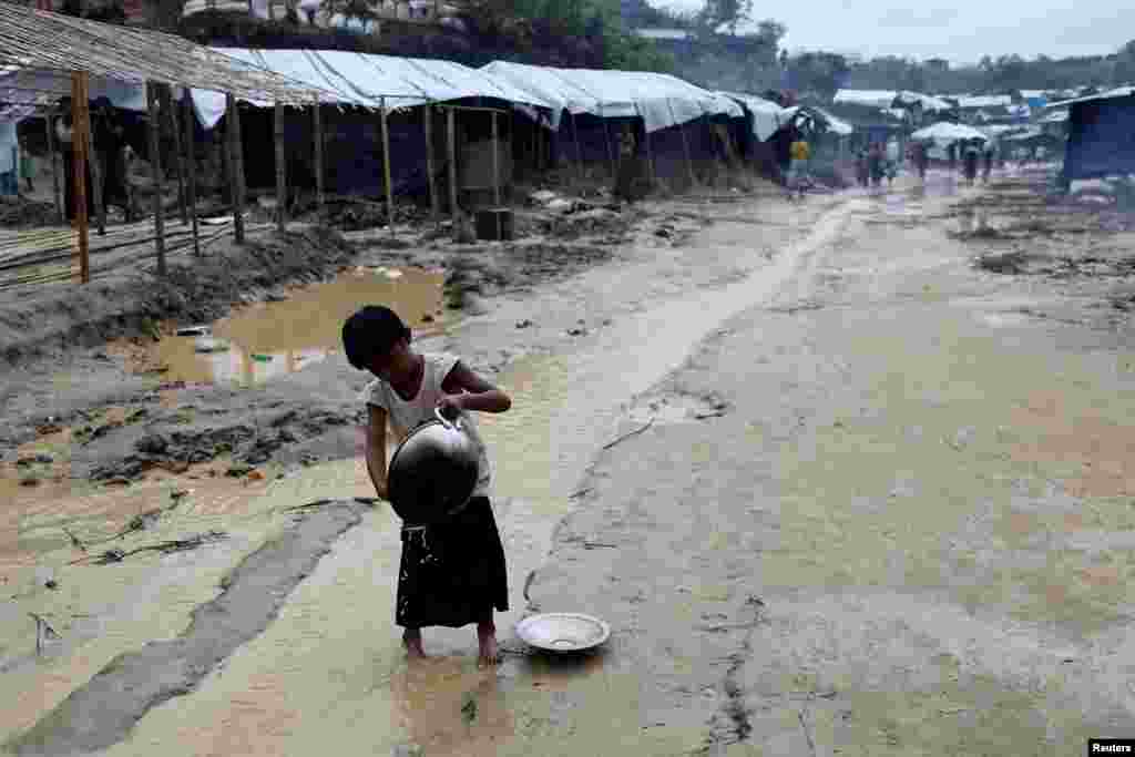 A Rohingya refugee child washes cooking utensils in the Balukhali refugee camp in Cox's Bazar, Bangladesh.