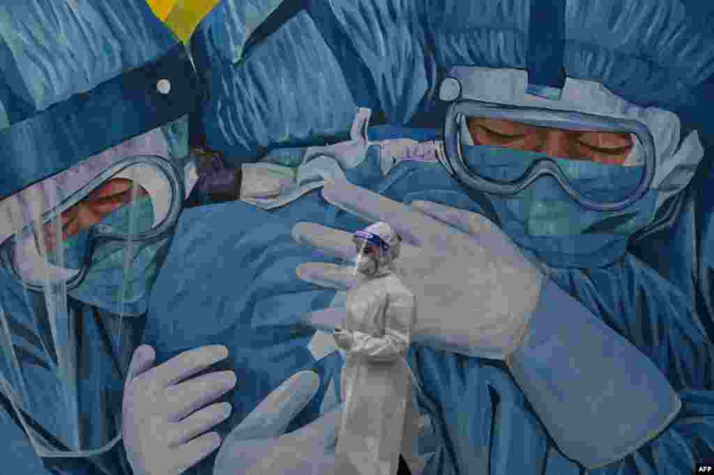 A medical personnel wearing a protective suit waits at the COVID-19 drive-thru test center outside the Ajwa Private Clinic in Shah Alam on the outskirts of Kuala Lumpur, as Malaysia's king declared a state of emergency to fight a coronavirus surge.