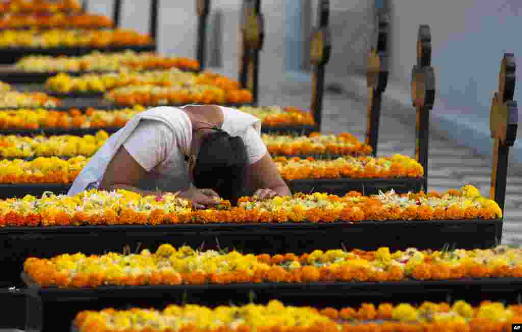 An Indian woman prays by a grave on All Souls&#39; Day in Hyderabad, India.