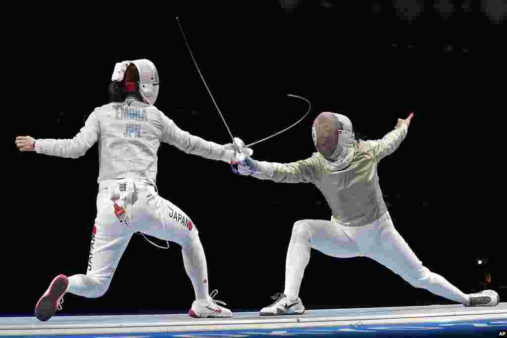Misaki Emura of Japan, left, and Amira Ben Chaabane of Tunisia compete in the women's Sabre team round of 16 competition at the 2020 Summer Olympics, Saturday, July 31, 2021, in Chiba, Japan. (AP Photo/Hassan Ammar)
