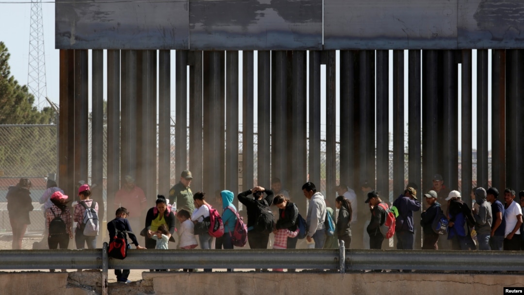 FILE - Migrants queue to request asylum after crossing illegally into El Paso, in this picture taken from Ciudad Juarez, Mexico, April 21, 2019.