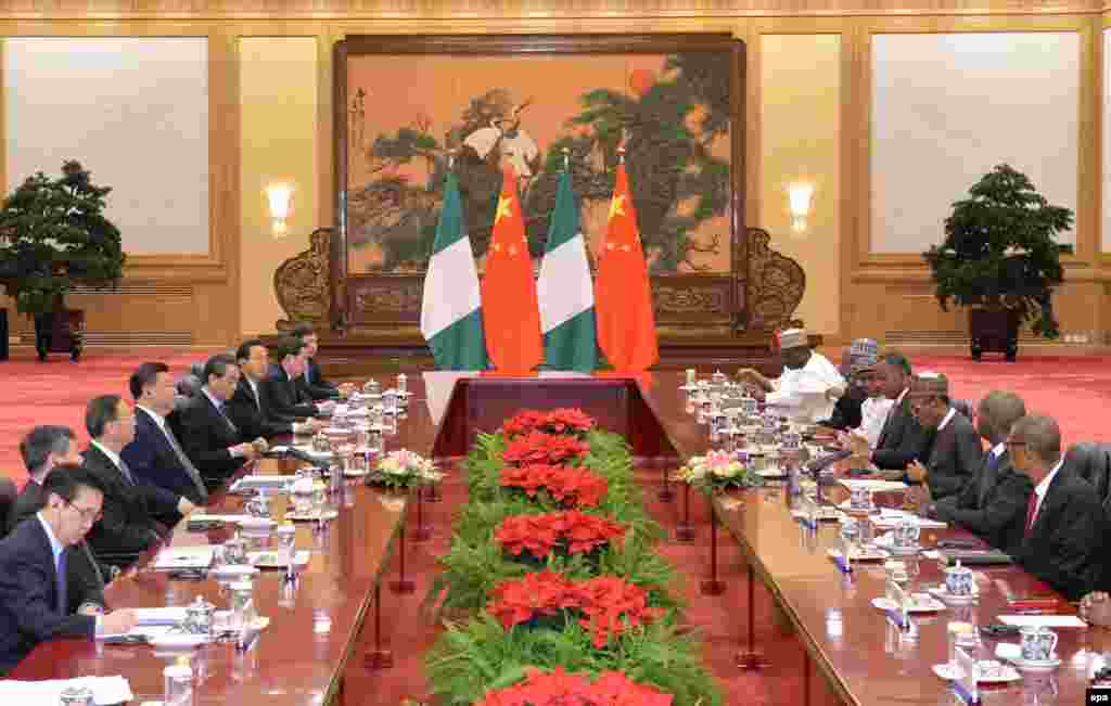 Shugaba Muhammadu Buhari na Najeriya da shugaba Xi Jinping na kasar Sin su na tafawa a yayin da wakilan tawagoginsu suke gaisawa a Babban Dakin Taron Al'umma dake birnin Beijing, talata 12 Afrilu 2016