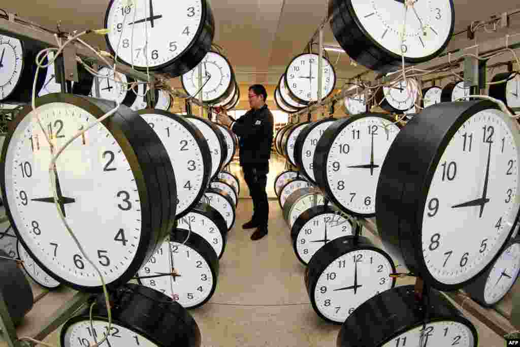 A technician checks hanging clocks at a clock company in Yantai, in eastern China's Shandong province.