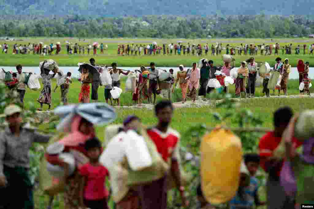 Rohingya refugees, who crossed the border from Myanmar two days before, walk after they received permission from the Bangladeshi army to continue on to the refugee camps, in Palang Khali, near Cox's Bazar, Bangladesh.