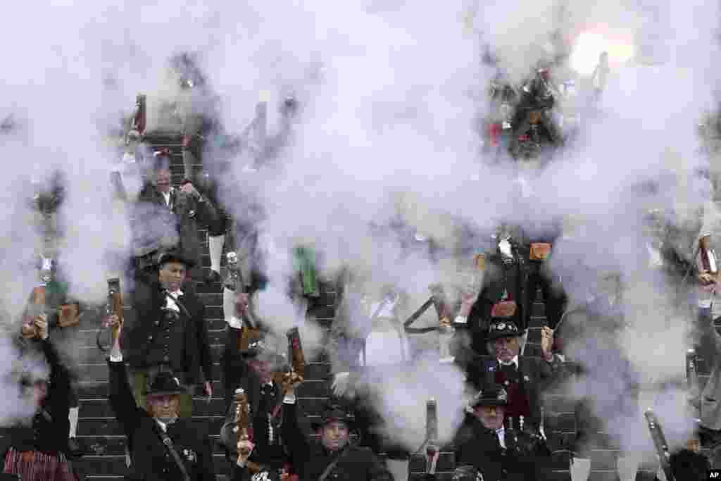 Bavarian riflemen and women in traditional costumes fire their muzzle loaders in front of the 'Bavaria' statue on the last day of the 184th Oktoberfest beer festival in Munich, Germany.