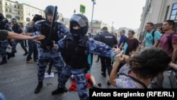 Russia -- Riot police use batons during an opposition rally in Moscow on July 27, 2019. Thousands of people took to the streets to protest the banning of opposition candidates from municipal elections set for September 8. 