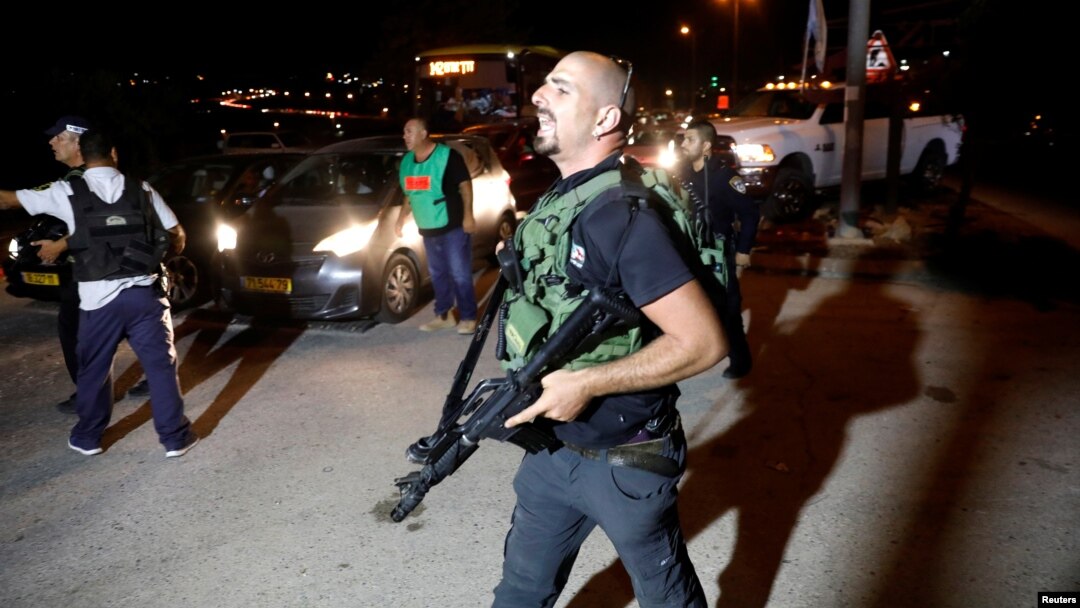 A security guard walks into the Israeli settlement Adam after a Palestinian assailant stabbed three people, one fatally, and then was shot and killed, according to the Israeli military, in the occupied West Bank, July 26, 2018. 