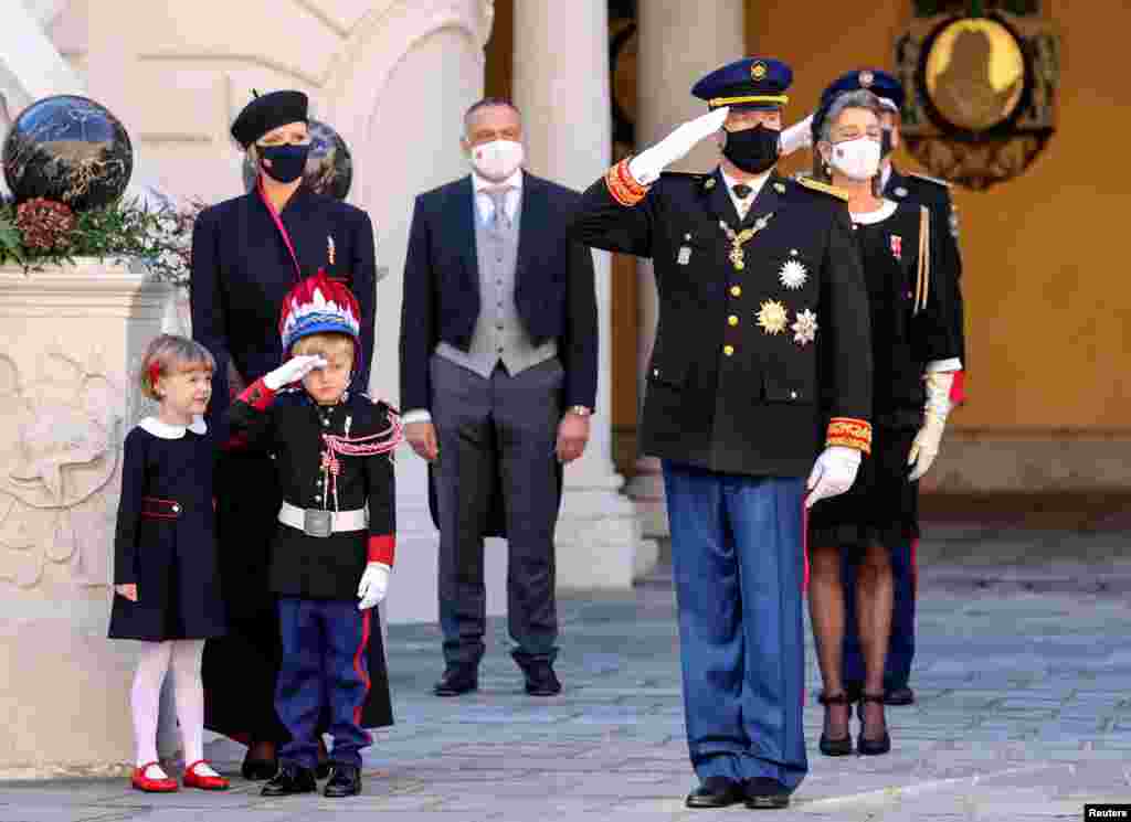 Prince Albert II and Prince Jacques salute as Princess Charlene and Princess Gabriella watch during celebrations marking Monaco's National Day at the Palace.