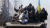 Ukraine -- Ukrainian soldiers ride an armoured personnel carrier (APC) as they leave the eastern Ukrainian city of Debaltseve, 18Feb2015