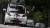 FILE - A self-driving vehicle goes onto the road during a demonstration at a business park in Singapore, Oct. 12, 2015.