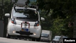 FILE - A self-driving vehicle goes onto the road during a demonstration at a business park in Singapore, Oct. 12, 2015.