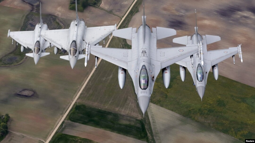 FILE - Norwegian F-16 fighters, right, and Italian Typhoon fighters patrol over the Baltics during a NATO air policing mission from Zokniai air base near Siauliai, Lithuania, May 20, 2015.