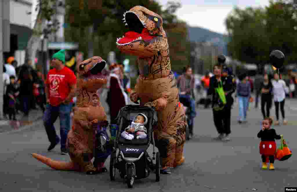 People wearing costumes walk on the street during Halloween in Sierra Madre, California, Oct. 31, 2017.